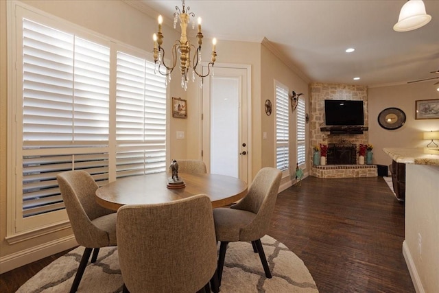 dining area with ceiling fan with notable chandelier, a stone fireplace, and dark wood-type flooring