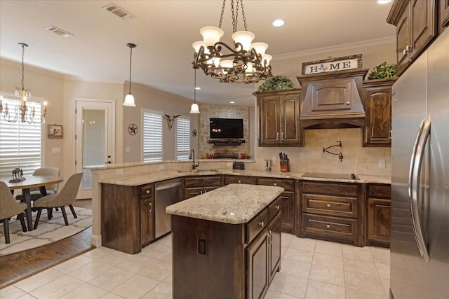 kitchen with decorative light fixtures, a kitchen island, and stainless steel appliances