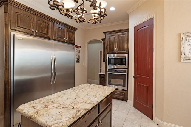 kitchen with built in appliances, pendant lighting, dark brown cabinetry, and a chandelier