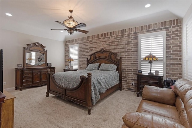 carpeted bedroom with ceiling fan and brick wall