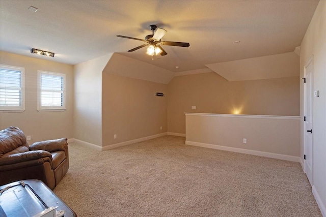 unfurnished living room with ceiling fan, light colored carpet, and lofted ceiling