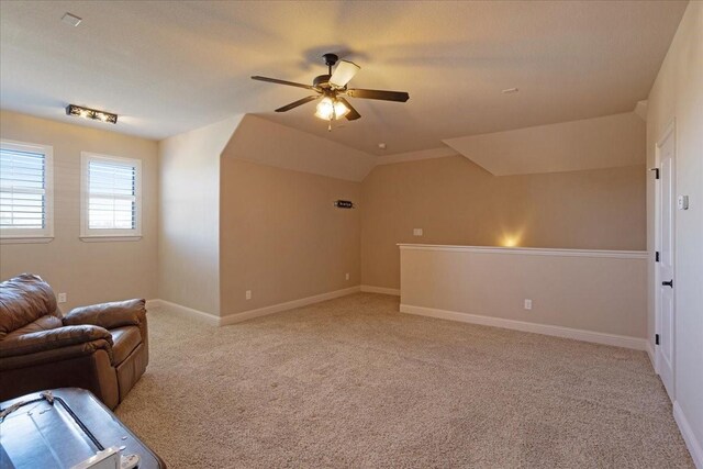 unfurnished living room with lofted ceiling, light colored carpet, and ceiling fan