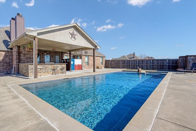 view of pool with a bar and a patio