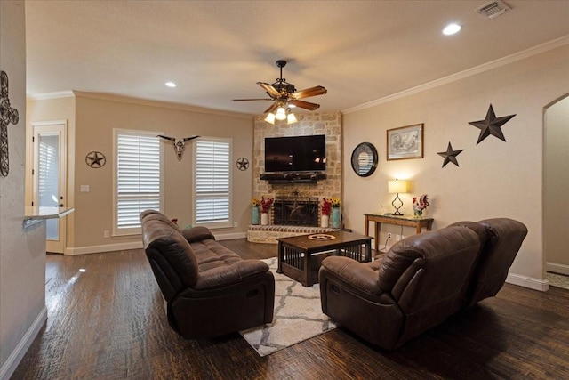 living room with a fireplace, dark hardwood / wood-style floors, ceiling fan, and crown molding