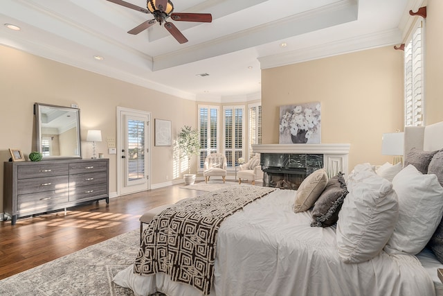 bedroom with a raised ceiling, ceiling fan, dark hardwood / wood-style floors, access to exterior, and a fireplace