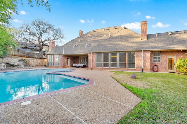 view of swimming pool with an in ground hot tub, a patio area, and a lawn