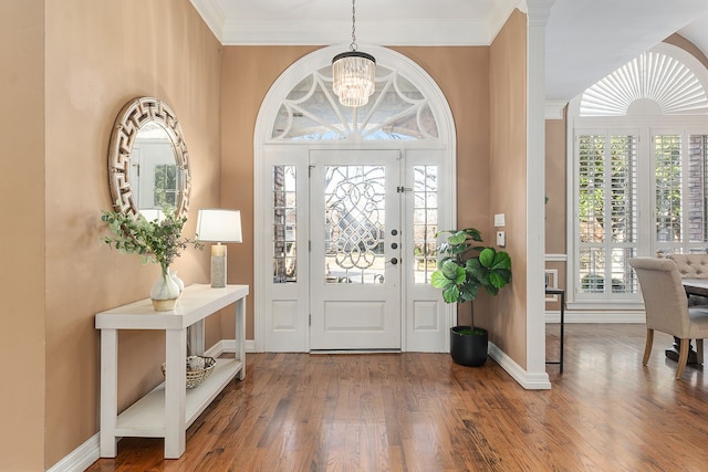 foyer entrance featuring crown molding, a chandelier, and wood-type flooring