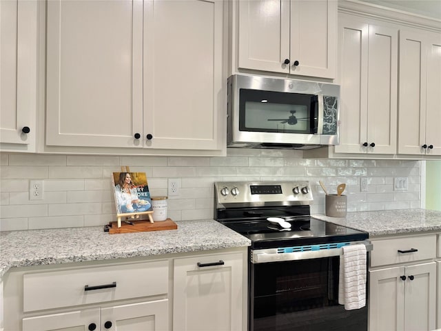 kitchen featuring backsplash, white cabinets, and stainless steel appliances