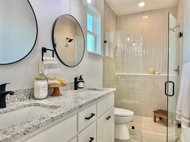 bathroom featuring an enclosed shower, vanity, and toilet