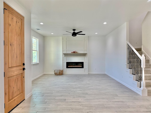 unfurnished living room with ceiling fan