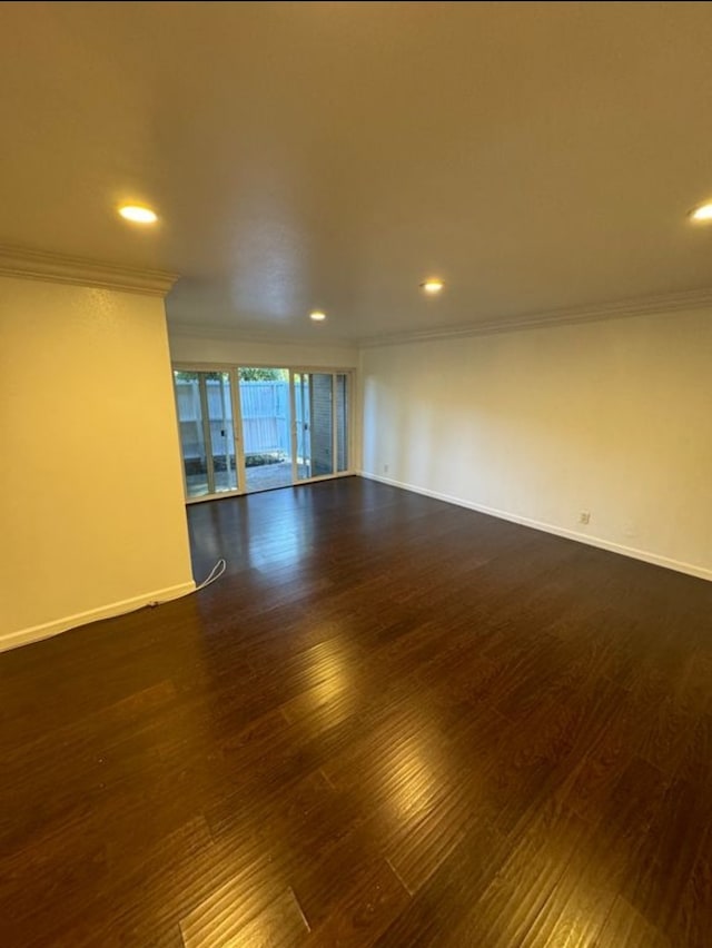 spare room with dark wood-type flooring and crown molding