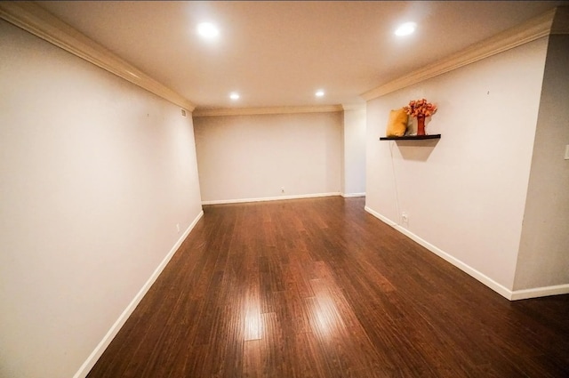 spare room with dark hardwood / wood-style flooring and crown molding