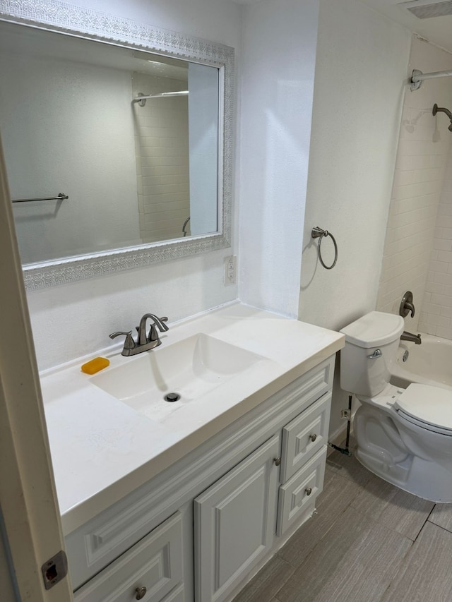 full bathroom with vanity, toilet, and tiled shower / bath combo