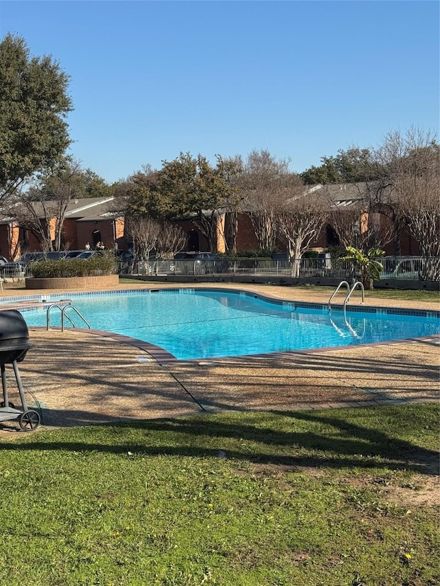 view of swimming pool featuring a lawn, area for grilling, and a patio