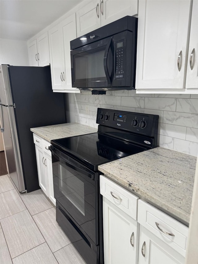 kitchen featuring black appliances, light stone countertops, white cabinetry, and tasteful backsplash