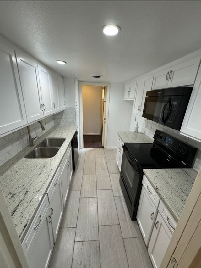 kitchen featuring black appliances, white cabinetry, sink, and tasteful backsplash