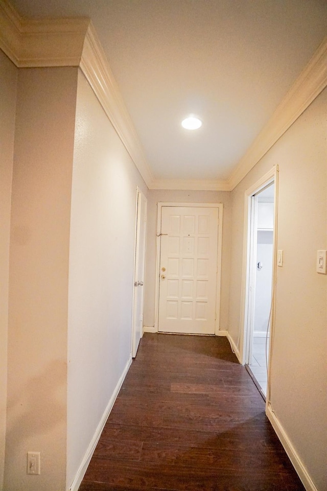 corridor with ornamental molding and dark wood-type flooring