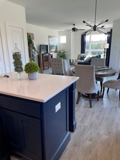 kitchen featuring blue cabinetry, a healthy amount of sunlight, and a notable chandelier