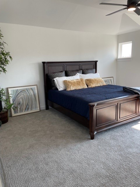 unfurnished bedroom with ceiling fan, carpet floors, and lofted ceiling