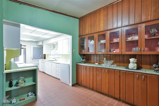 kitchen with white dishwasher, sink, wooden walls, and fridge