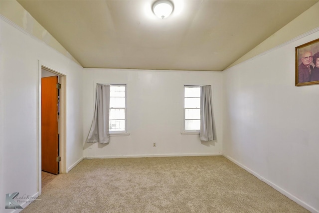 carpeted spare room featuring lofted ceiling