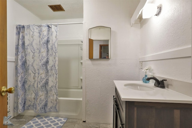 bathroom with vanity, a textured ceiling, and shower / tub combo with curtain