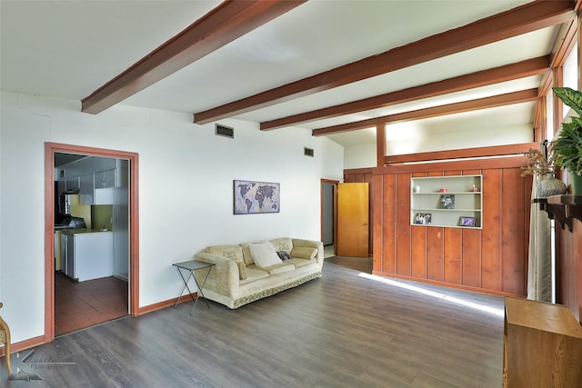 living room with beamed ceiling, built in features, and dark wood-type flooring