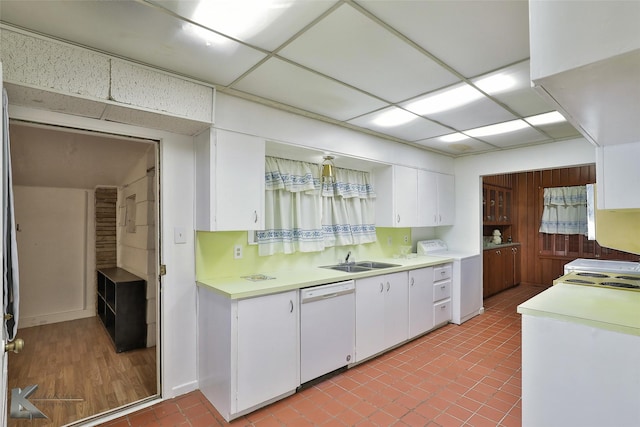 kitchen featuring dishwasher, a drop ceiling, white cabinetry, and washer / clothes dryer