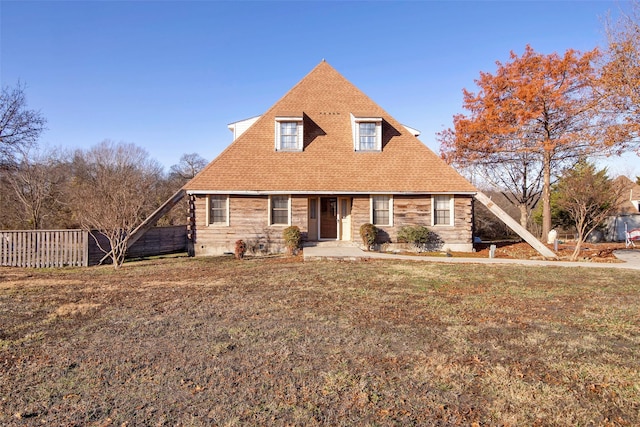 cape cod home featuring a front yard