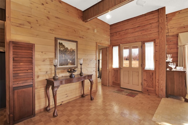 foyer with light parquet flooring and wooden walls