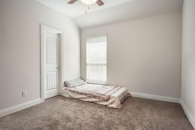 unfurnished bedroom featuring carpet, vaulted ceiling, and ceiling fan