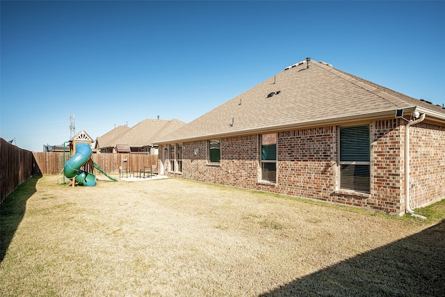 rear view of house featuring a playground