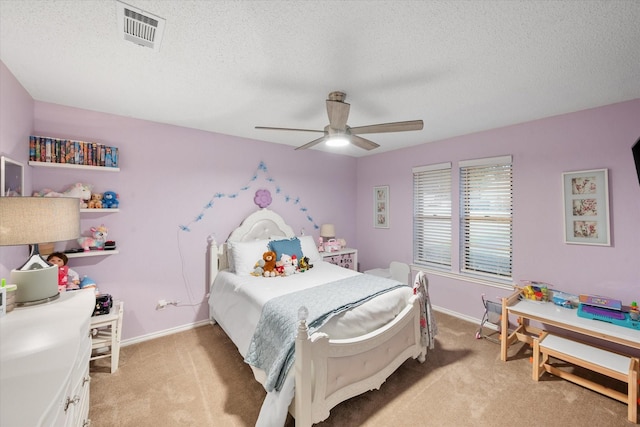 bedroom featuring a textured ceiling, light colored carpet, and ceiling fan