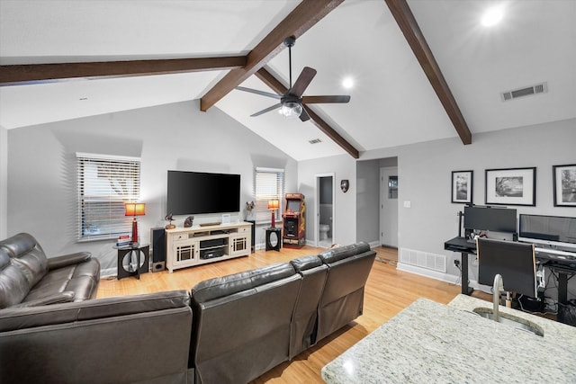 living room featuring lofted ceiling with beams, ceiling fan, plenty of natural light, and light wood-type flooring