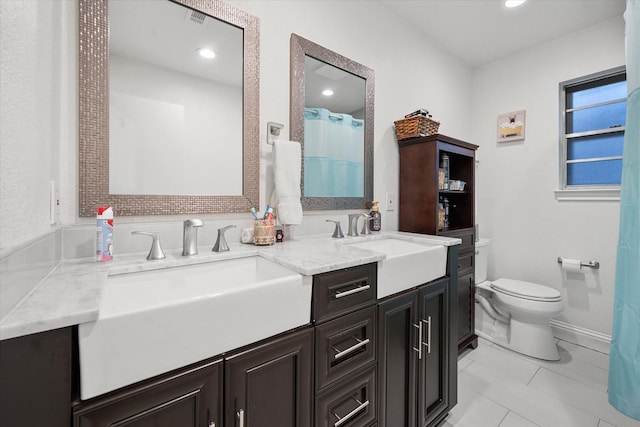 bathroom with tile patterned flooring, vanity, and toilet