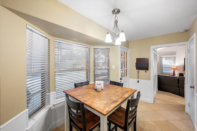 tiled dining area with an inviting chandelier