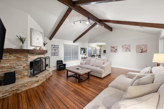 living room with vaulted ceiling with beams, a stone fireplace, wood-type flooring, and an inviting chandelier