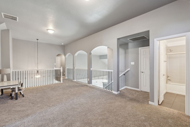 carpeted empty room featuring a textured ceiling