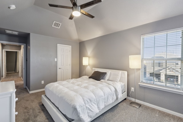 carpeted bedroom with ceiling fan, lofted ceiling, and a tray ceiling