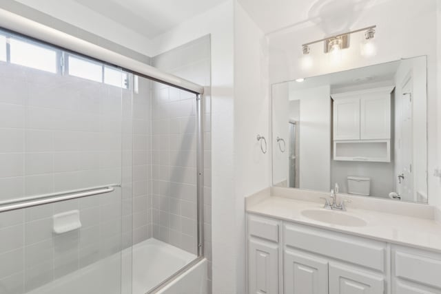 full bathroom with vanity, toilet, and bath / shower combo with glass door