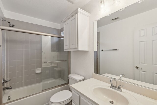 full bathroom featuring toilet, vanity, and combined bath / shower with glass door