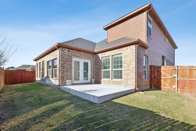 back of house featuring french doors, a patio, and a lawn