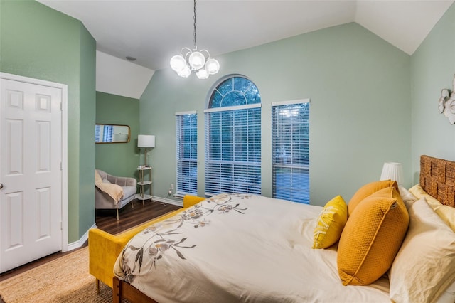 bedroom featuring lofted ceiling, wood-type flooring, and a chandelier