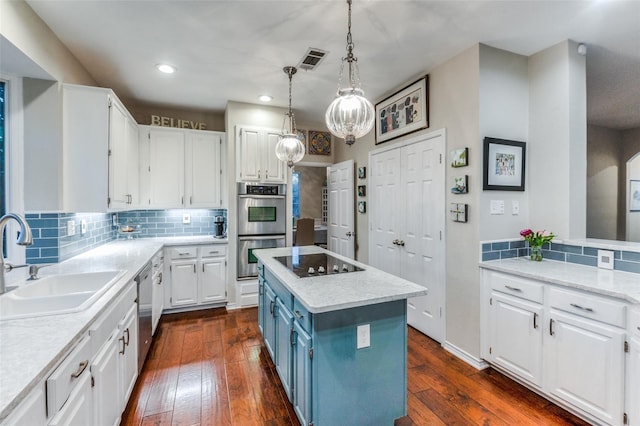 kitchen with white cabinetry, sink, appliances with stainless steel finishes, and a kitchen island