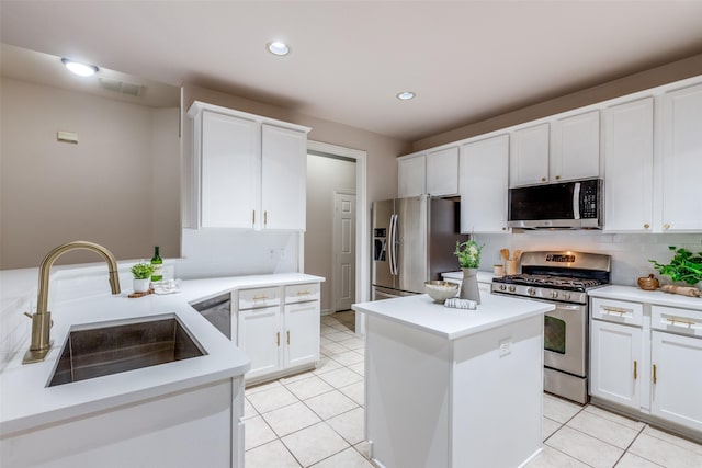 kitchen featuring tasteful backsplash, white cabinetry, sink, and appliances with stainless steel finishes