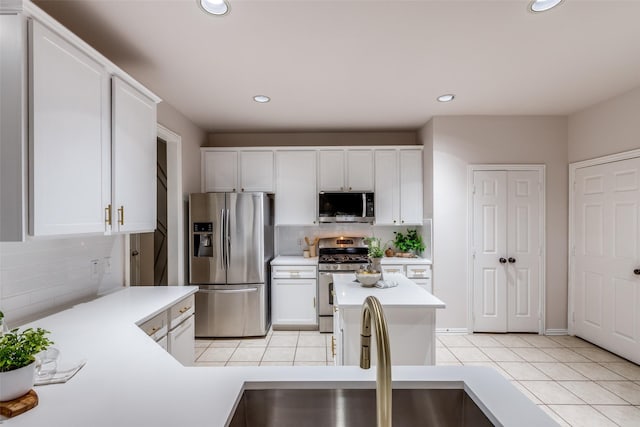 kitchen with backsplash, sink, white cabinetry, and stainless steel appliances