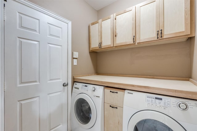 clothes washing area featuring cabinets and washing machine and dryer