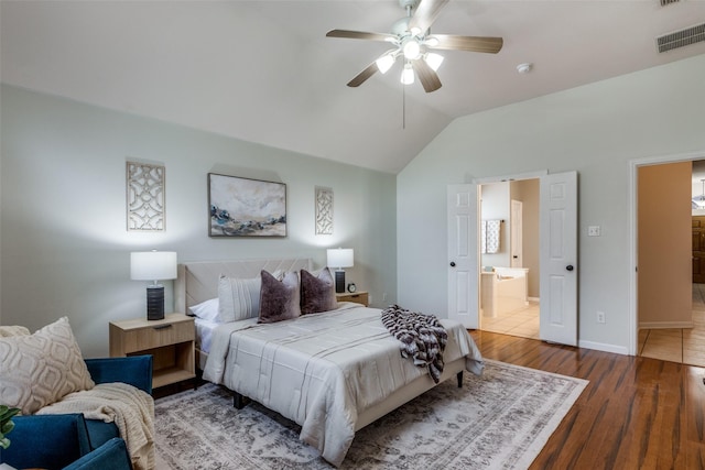 bedroom with dark hardwood / wood-style flooring, connected bathroom, vaulted ceiling, and ceiling fan