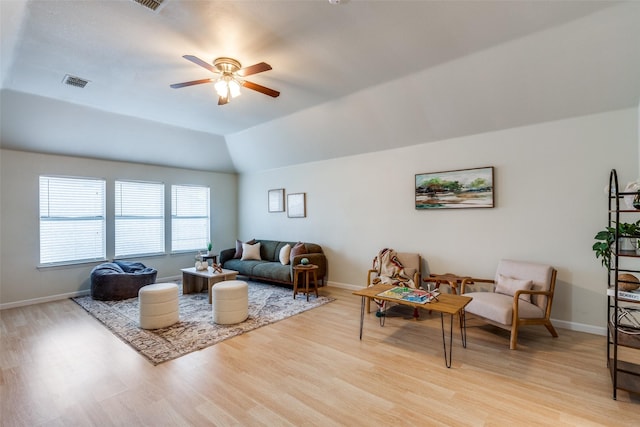 living room with ceiling fan, lofted ceiling, and light wood-type flooring