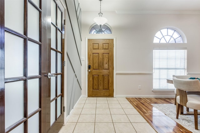 entrance foyer featuring light tile patterned flooring and ornamental molding